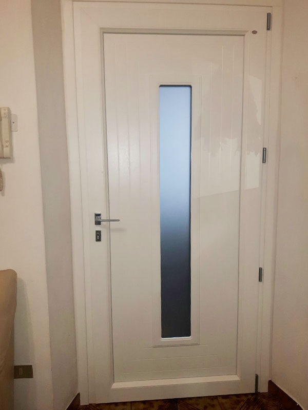 Portoncino di sicurezza in PVC con inserto centrale in vetro presso un appartamento a Cesano Boscone